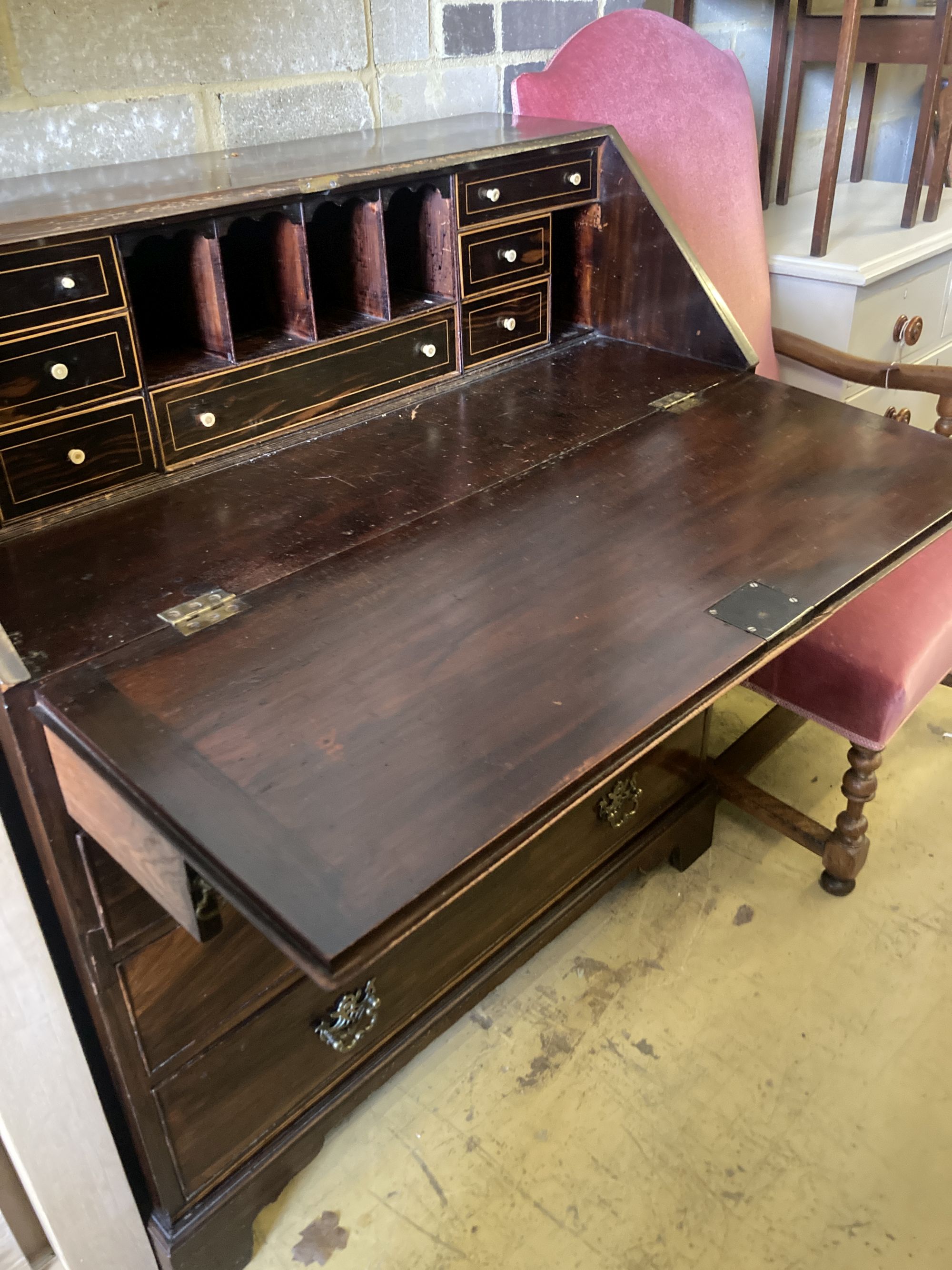 A George III mahogany bureau, the fall enclosing drawers, pigeon holes and secret compartments over four long drawers, width 97cm, dept